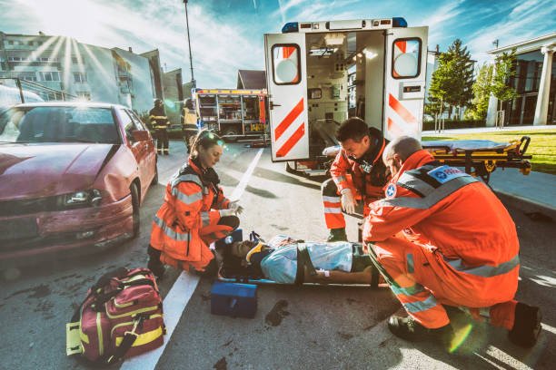 Paramedics providing first aid to man injured in car accident.